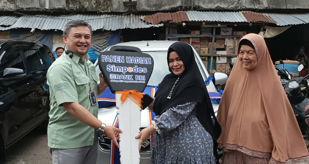 Pemimpin BRI Cabang Bumiayu, Denny Setiawan menyerahkan replika kunci mobil Suzuki All New Ertiga kepada pemenang hadiah grandprize PHS, Wike Indah Pertiwi, di halaman parkir Pasar Induk Bumiayu.